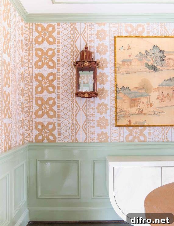 Dining space features orange batik wallpaper over mint green wainscoting.