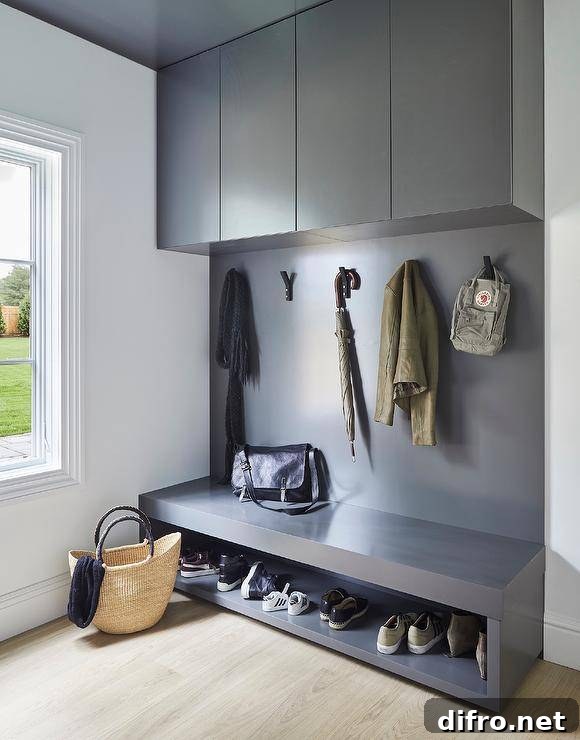 Mudroom bench with built-in shoe shelf under flat-front cabinets.