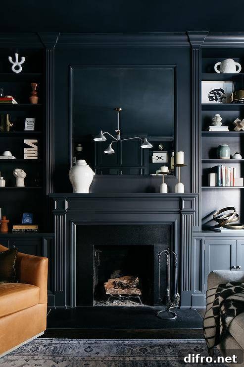 An inset framed mirror is fixed to a black wall over a black fireplace mantel flanked by styled black built-ins.