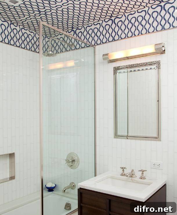 Ceiling Design Ideas to Add Personality to Your Home 11 Under a white and blue wallpapered ceiling, an inset framed medicine cabinet is fixed to white vertical wall tiles over a brown wooden washstand finished with a vintage cross handle faucet mounted to a marble countertop.
