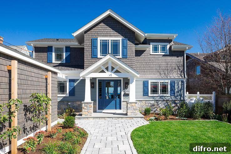Craftsman style home with gray shingles, a blue front door and stone paver walkway.