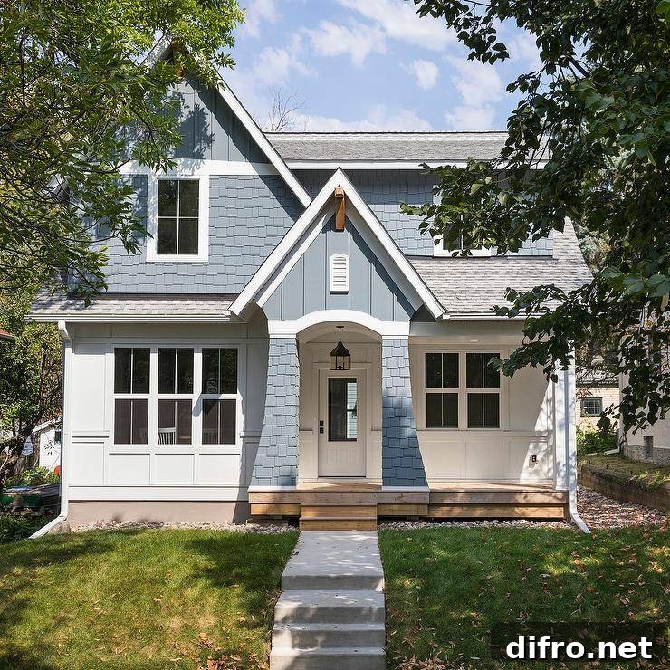 Charming blue bungalow with concrete steps and a blue portico.