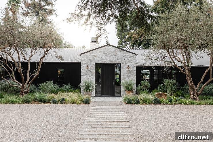 Modern one-story farmhouse with gray stone exterior and plank front door.