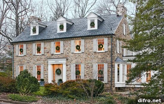 Cottage home with stone and stucco exterior accented with sash windows and pale gray shutters.