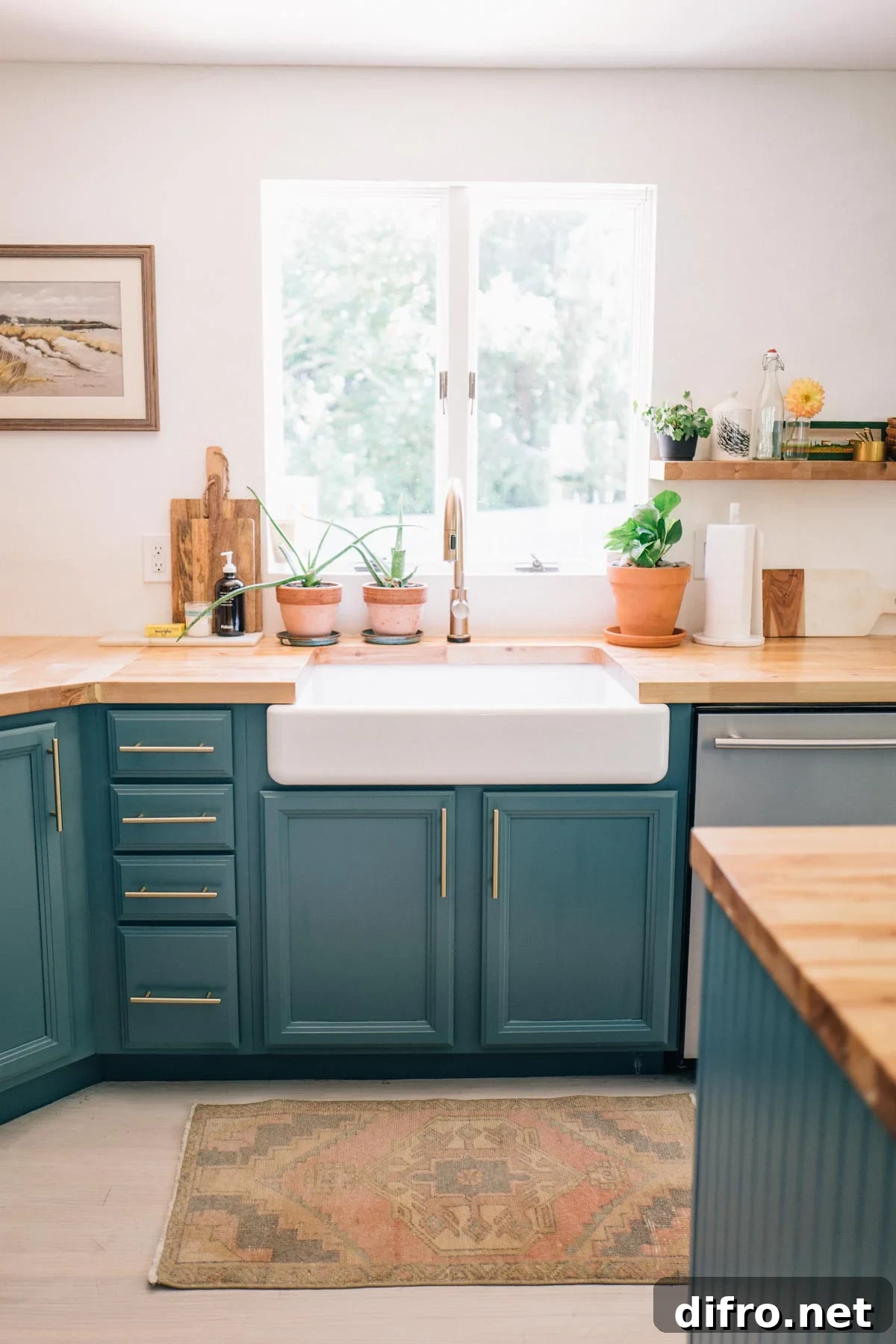 teal lower kitchen cabinets with butcher block top and deep white farmhouse sink