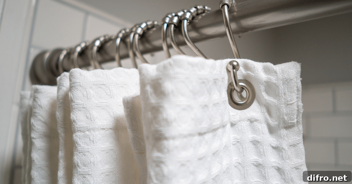 Closeup of fabric shower curtain hung on metal hooks with rollers.