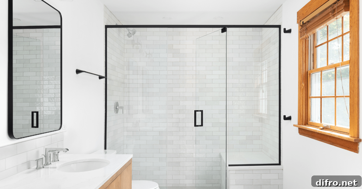 White themed bathroom with a glass shower flanked by subway tile shower.