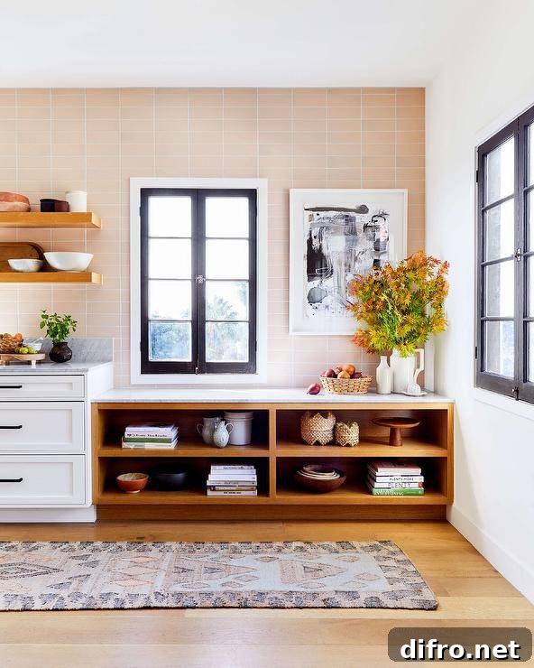 Large kitchen features open shelves fixed against pink backsplash tiles framing a casement window.