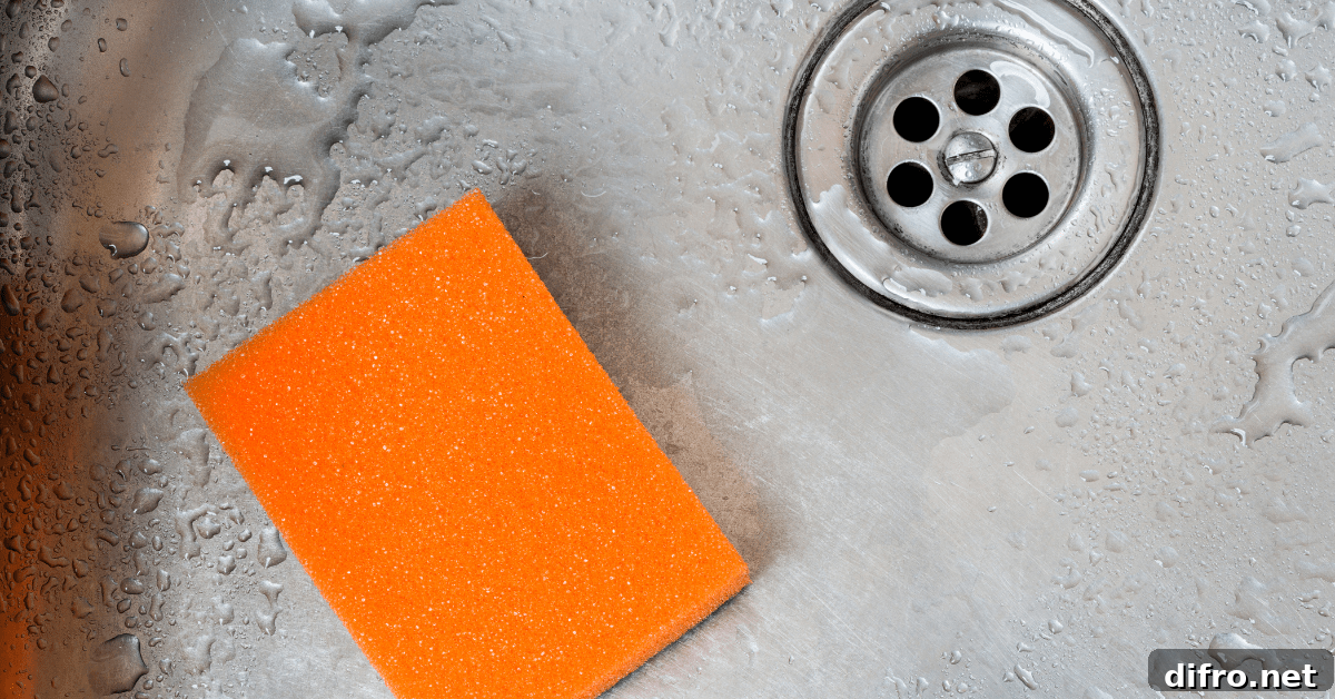 Orange sponge in a stainless steel sink.