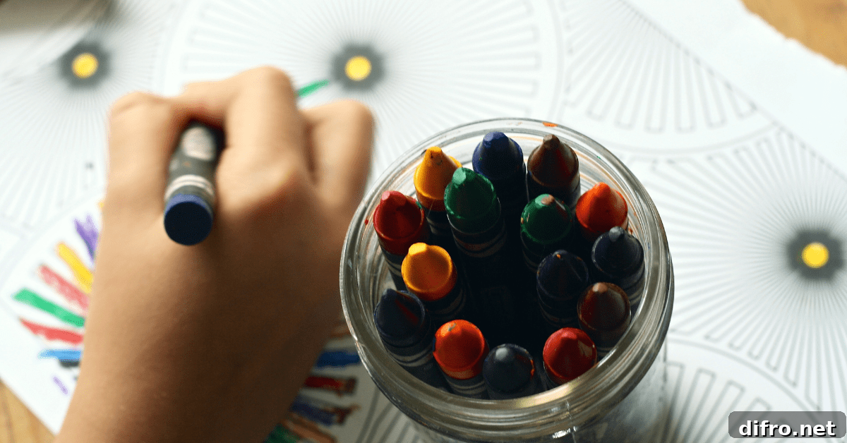 Closeup of someone's hands using crayons on paper.