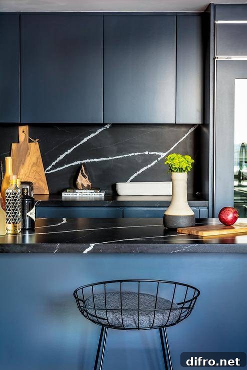 Blue and black chic contemporary kitchen with a blue island topped with a honed black marble countertop and matching blue cabinets.