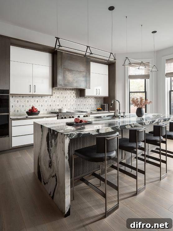 Kitchen features a black and white waterfall edge island with metal trim tiled backsplash and white and gray cabinets.