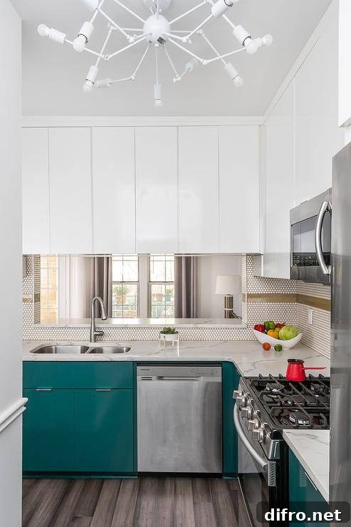 Contemporary kitchen lit by a white modern chandelier in front of stainless steel oven range and peacock blue cabinets.