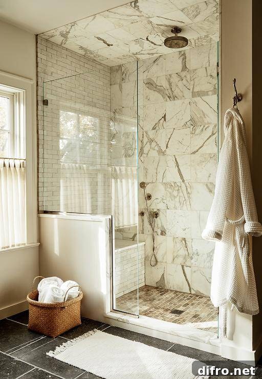 Marble grid walk in shower features gray marble offset floor tiles, a marble slab shower bench and clear shower partition.