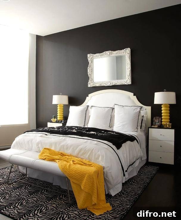 Black and white bedroom with yellow accents features a black accent wall holding a white baroque mirror over a white French headboard.