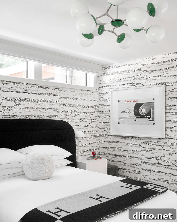 Black and white modern boy's room features a black channel tufted headboard accent and a white nightstand on patterned wallpaper.