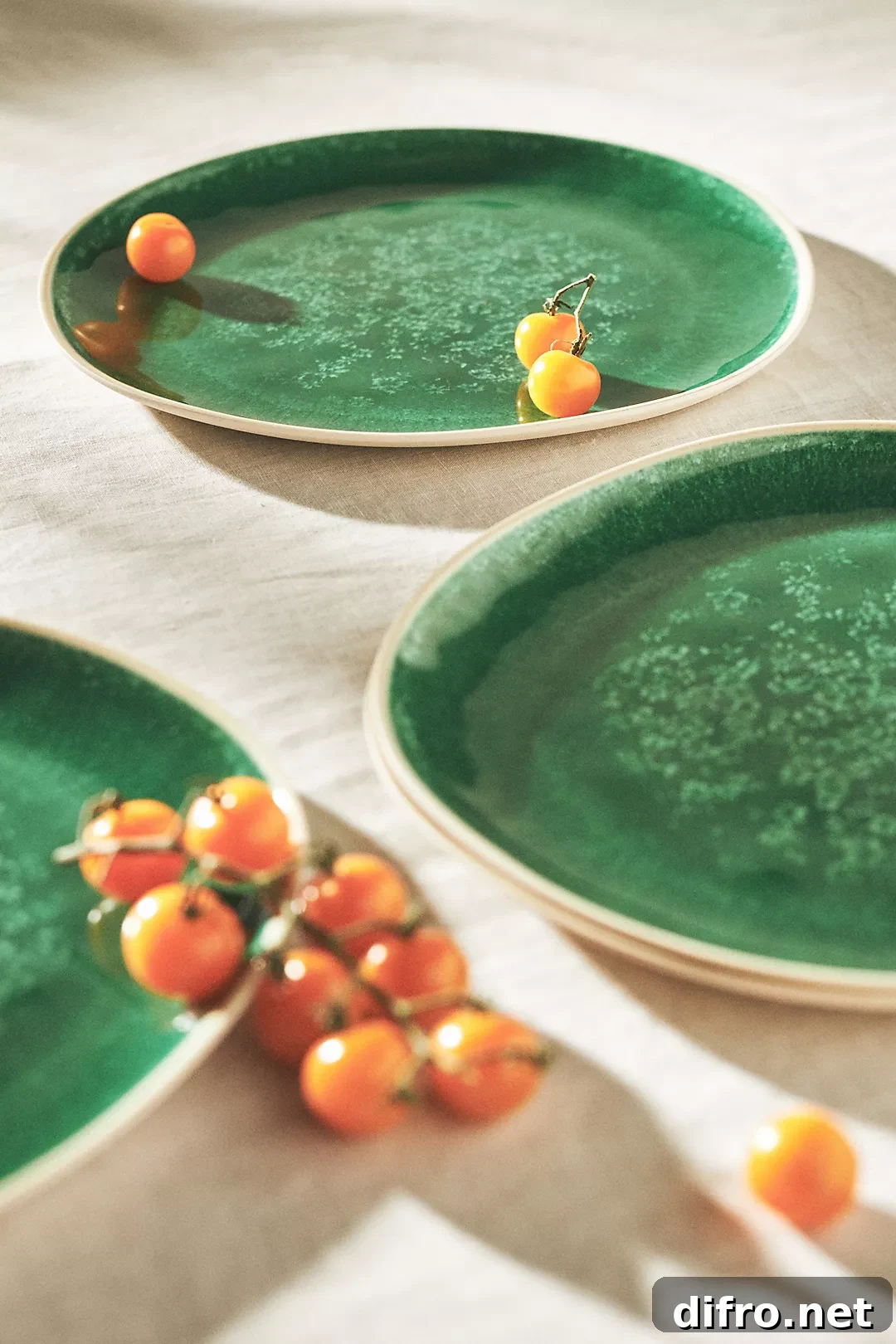 green dinner plates product photo with small orange tomatoes on them