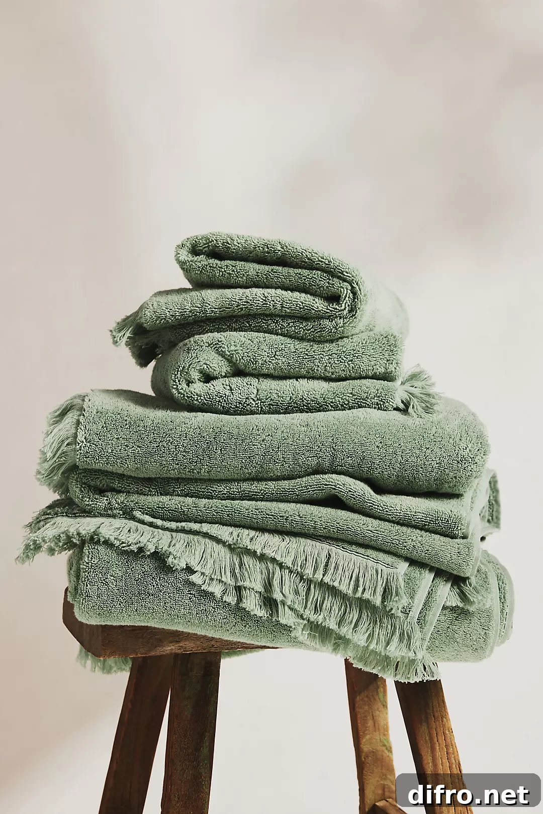 green bath towels folded on stool