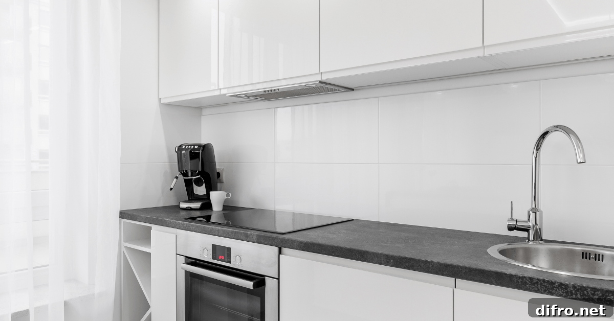 A white modern kitchen with black countertops.