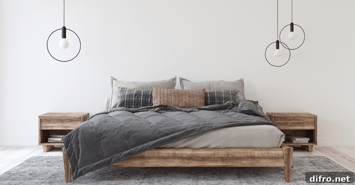 A bedroom with grey comforter and rug.