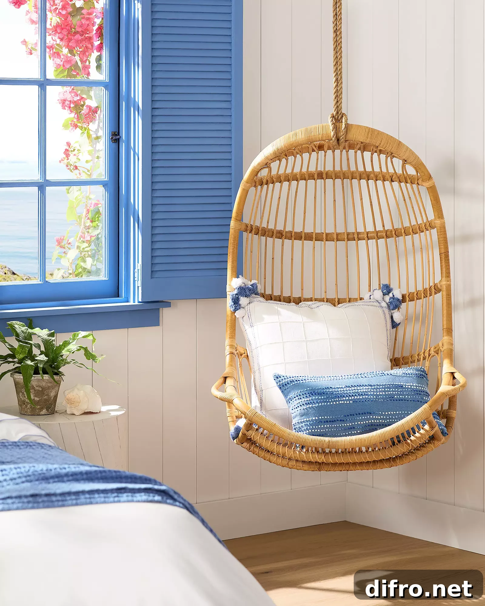 hanging rattan chair in room with blue theme boho coastal decor