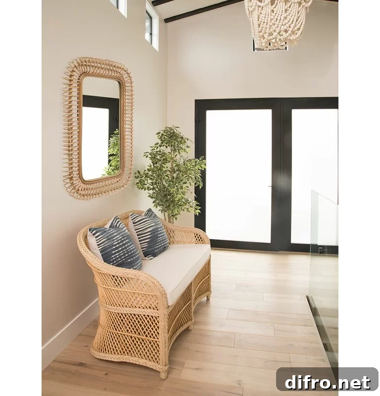 Rattan Wall Mirror hanging on wall in entryway above a rattan loveseat