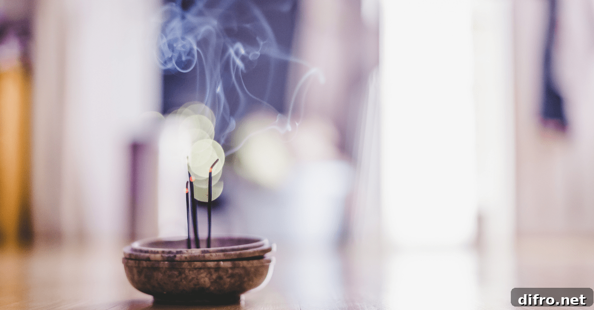 A scent stick in a bowl lit and producing smoke.