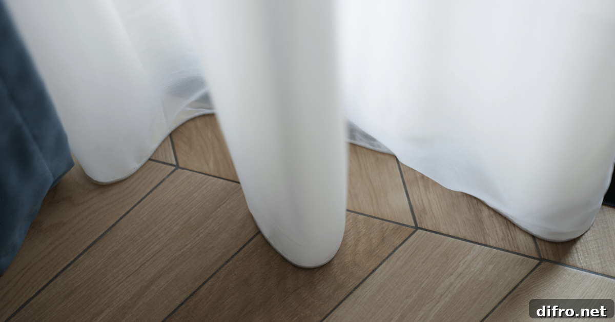 A white curtain with perfect length almost touching floor.