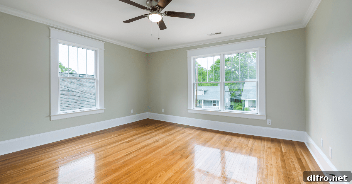 A room with polished wood floors, white ceiling, and beige walls.