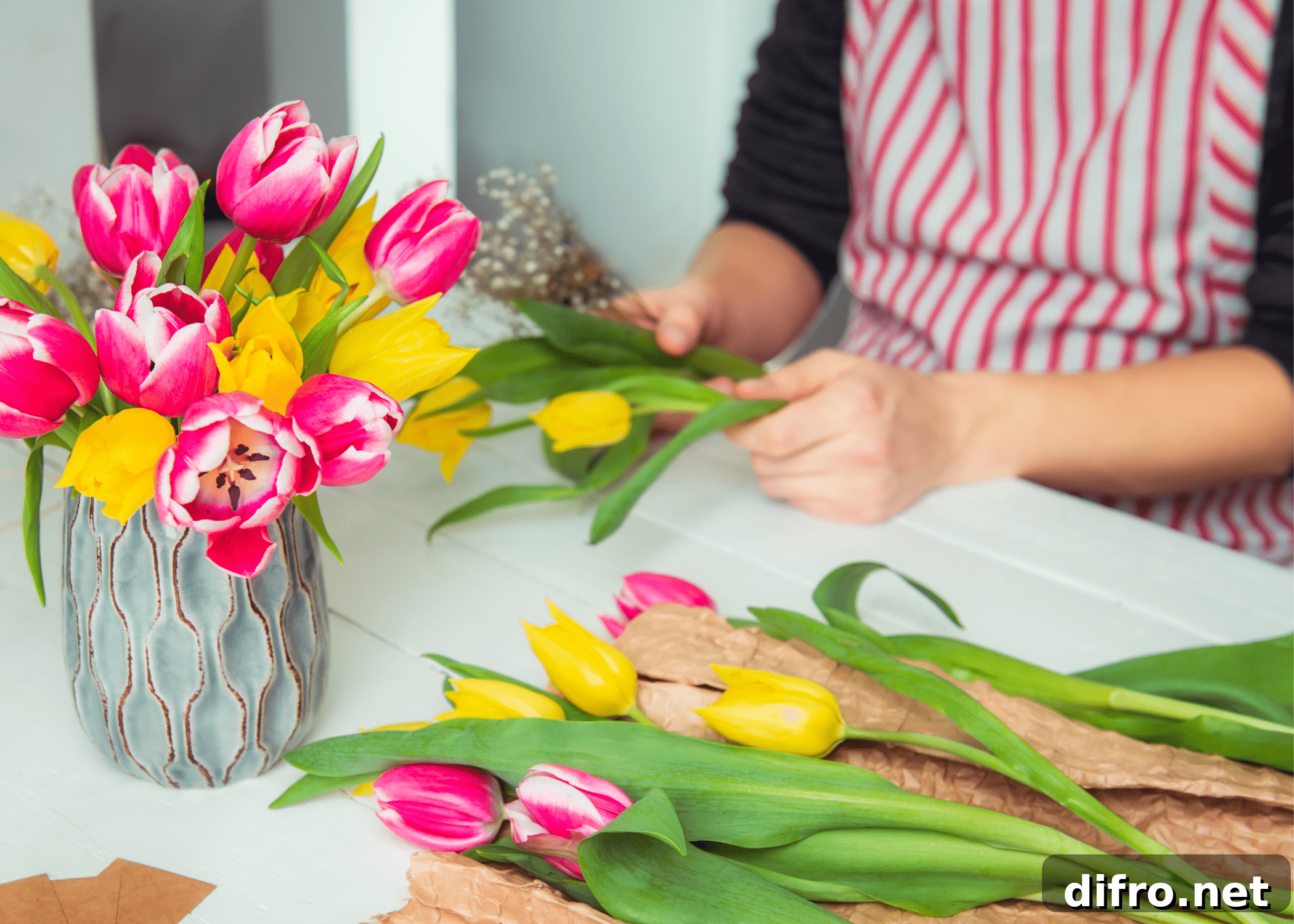 woman arranging tulips in a vase