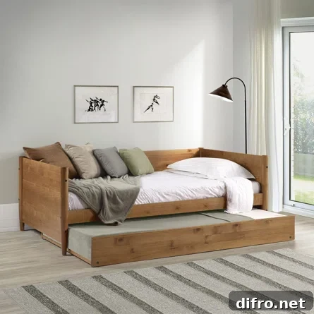 wood day bed from Wayfair in living room with black standing lamp trundle and pillows