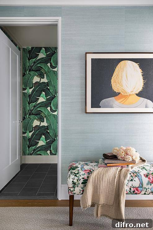 Floral bench sits on blue grasscloth wallpaper outside of a powder room.