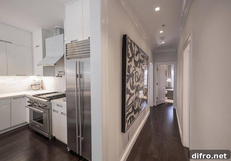 Artwork energizes a narrow hallway, brightening the center of an apartment.