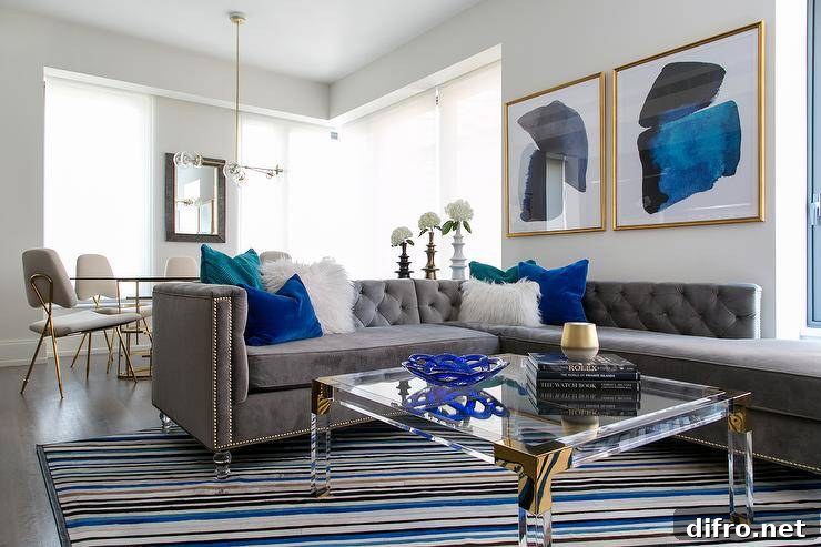 Modern living room with gray tufted sectional and a bold area rug.