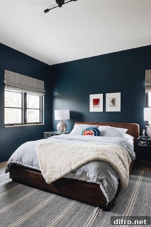 Bold blue walls accent a boy's bedroom with leather bed and soft textiles