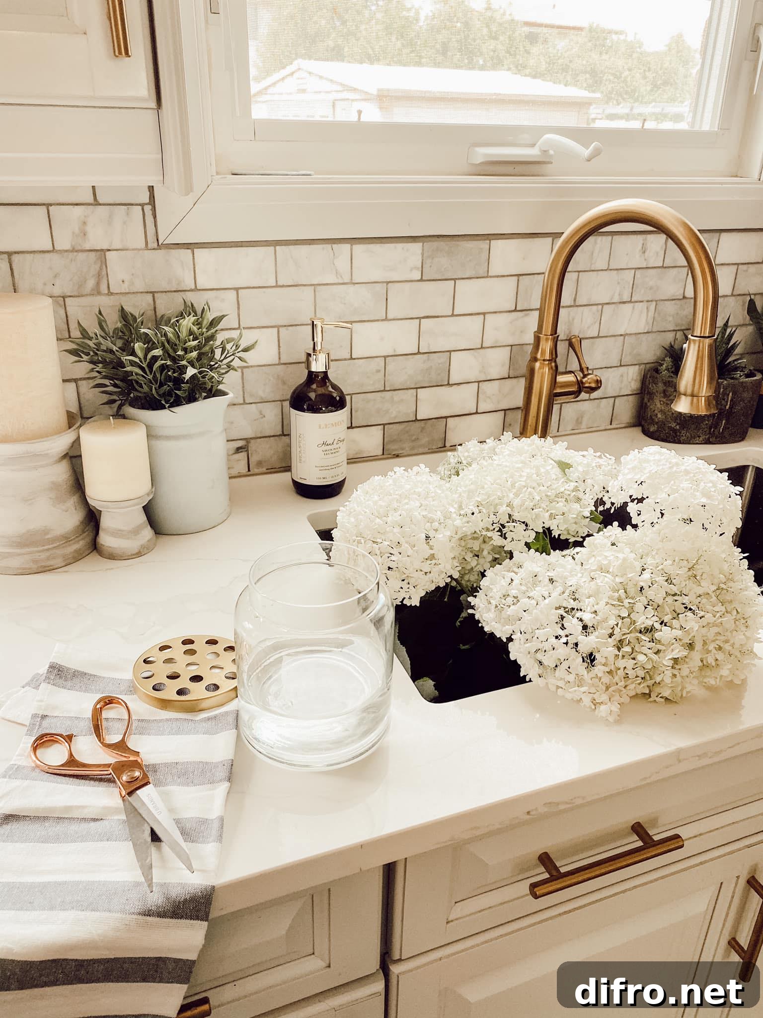 sink filled with white hydrangea gold faucet