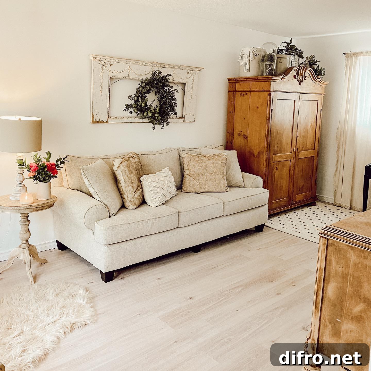 white living room with wood antique wardrobe throw pillows wreath hanging on architecture