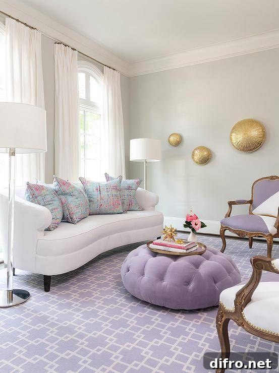 White curved sofa with colorful decorative pillows and a purple ottoman.
