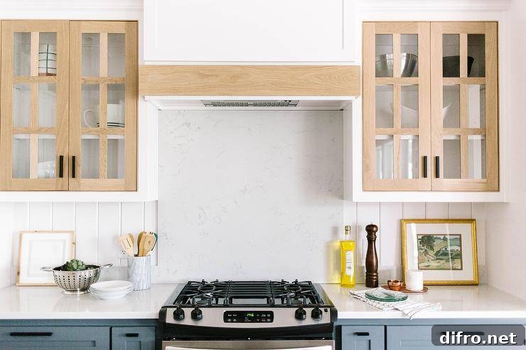 Blue kitchen cabinets accented with oil rubbed bronze hardware and a white quartz countertop.