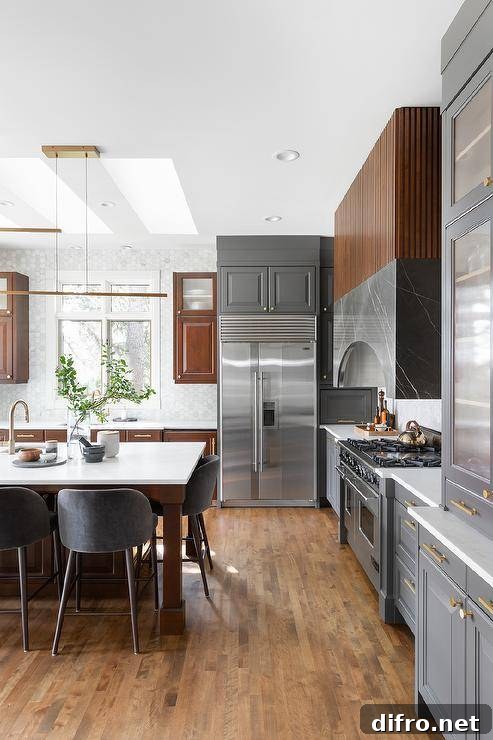 Kitchen with reeded cabinetry, gray marble hood and two tone cabinetry.