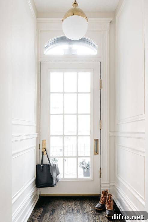 A glass paneled white door beneath an arched transom window.