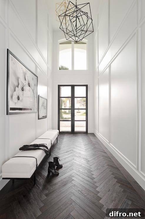 Galley style two story foyer with a black frame glass panel front door.