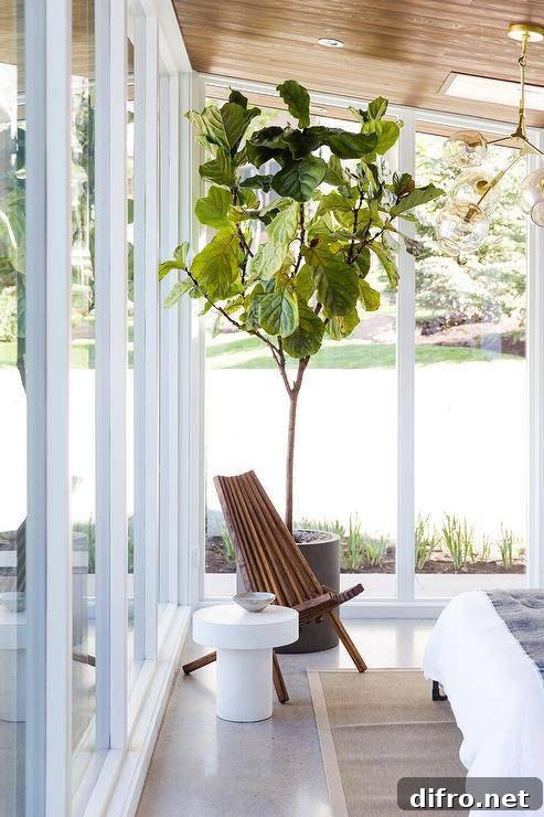 Sunroom used as a bedroom with oak plank ceiling and wooden accent chair