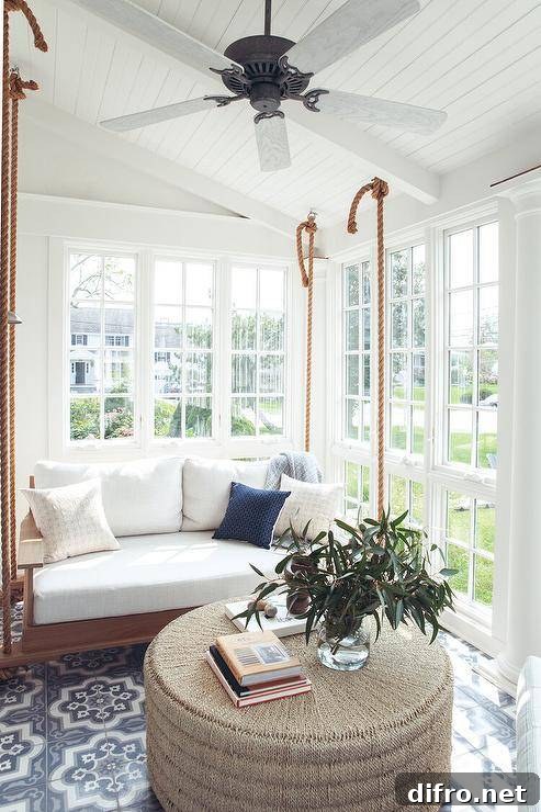 Sunroom with hanging swing sofa and woven ottoman