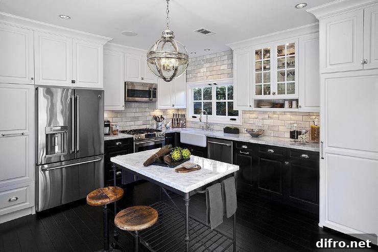 L-shaped kitchen with white upper cabinets, black lower cabinets and marble countertops.