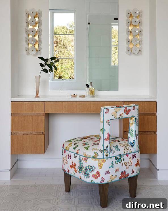 A butterfly print stool sits at a brown veneer floating makeup vanity fixed under a frameless vanity mirror lit by white and gold sconces.