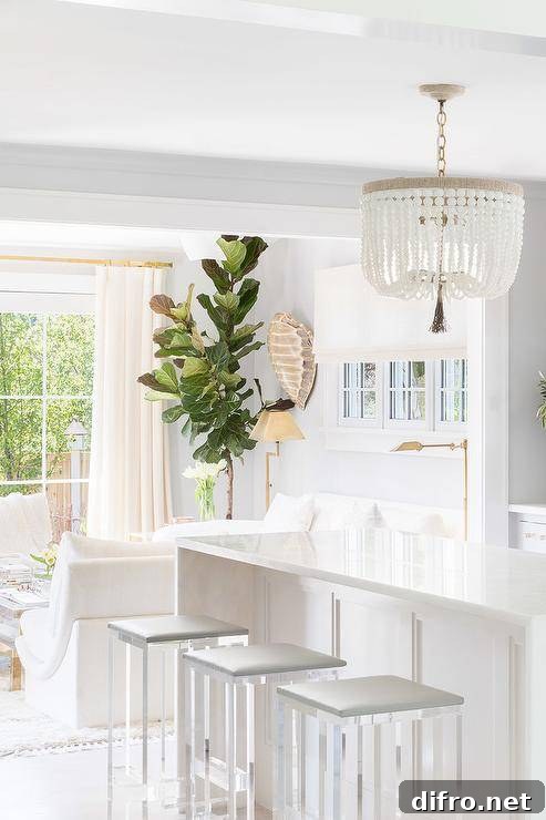 Display of a white beaded chandelier over a white waterfall quartz island.
