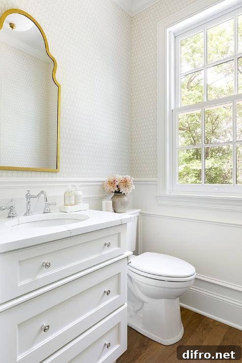 White and gold powder room features a nickel chair rail and white wainscoting.