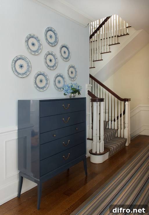 Hallway with blue wall plates hung above a chest of drawers.
