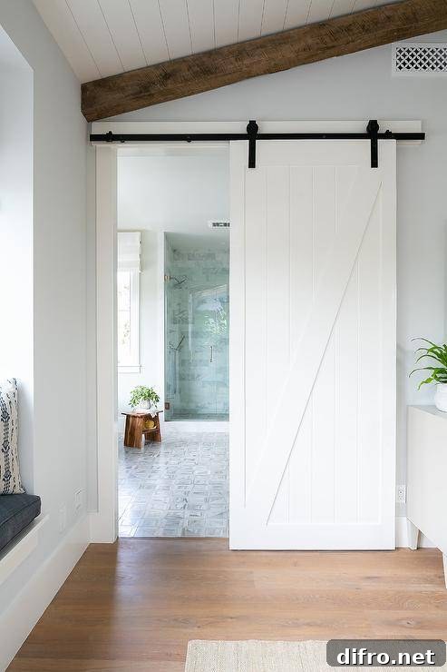 A shiplap barn door on rails slides open to reveal a stunning master bathroom.